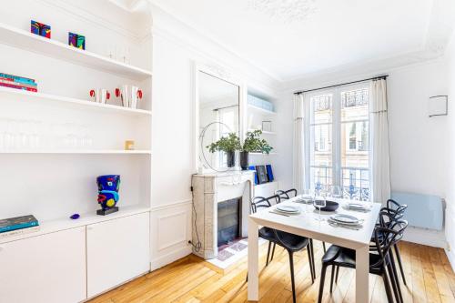 une salle à manger blanche avec une table et des chaises dans l'établissement GuestReady - Charming home in the 15th Arr., à Paris