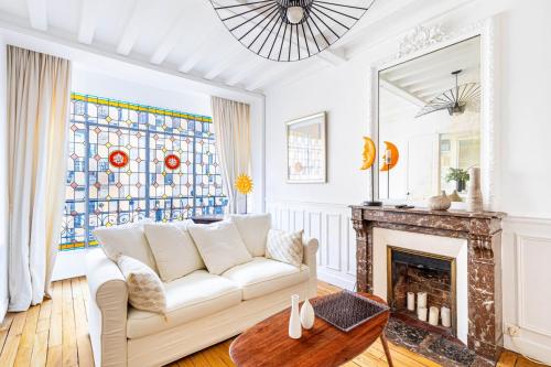 un salon avec un canapé blanc et une cheminée dans l'établissement GuestReady - Charming home in the 15th Arr., à Paris