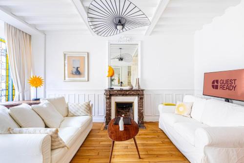 Elle comprend un salon doté d'un mobilier blanc et d'une cheminée. dans l'établissement GuestReady - Charming home in the 15th Arr., à Paris