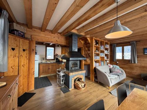 - un salon avec une cheminée dans une cabane en rondins dans l'établissement Chalet confortable à Méaudre pour 8 pers, vue imprenable - FR-1-737-98, à Méaudre