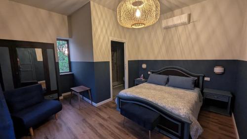 a bedroom with a bed and a chair and a chandelier at A Casa di Nonna in SantʼAngelo in Theodice