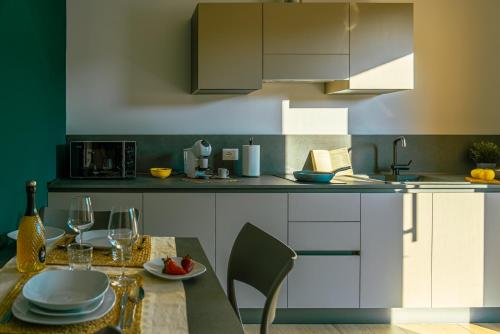 Una cocina con una mesa con platos y copas de vino. en Alloggi Celly Appartamento piano terra, en San Vendemiano