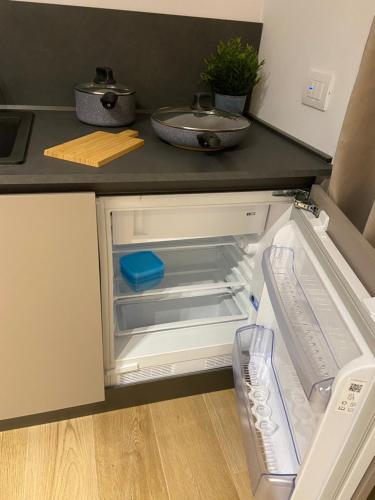 Un refrigerador vacío con la puerta abierta en una cocina. en Alloggi Celly Appartamento piano terra, en San Vendemiano