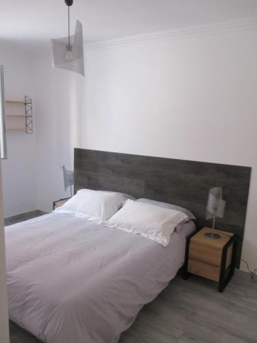 une chambre avec un grand lit avec une tête de lit en bois dans l'établissement Nice Apartment Old Town, à Nice