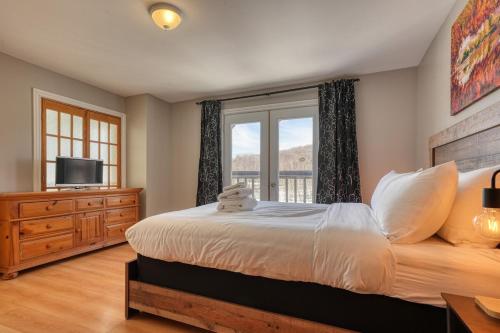 Ένα ή περισσότερα κρεβάτια σε δωμάτιο στο Cozy Lakefront Chalet Lac Lacasse