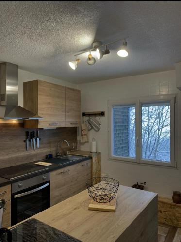 une cuisine avec des armoires en bois et un comptoir dans l'établissement La Verrière du Sancy, à Picherande