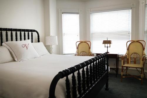a bedroom with a large bed and a desk and chairs at The Red Cottage in Cape May