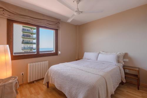 a bedroom with a white bed and a window at Marbella Port Beachfront - EaW Homes in Marbella