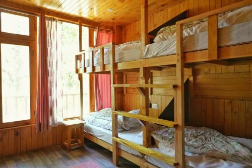 a bedroom with bunk beds in a cabin at Ailyak Stays and Cafe, Shoja, Jibhi in Shoja