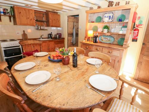 a kitchen with a wooden table with plates and wine glasses at Sycamore Tree Farm in Outhgill
