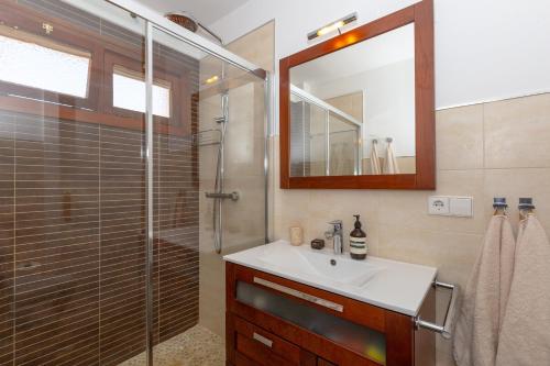 a bathroom with a sink and a shower with a mirror at Marbella Port Beachfront - EaW Homes in Marbella