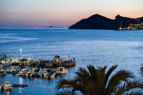 a group of boats docked in the water at dusk at Apartamentos Brisas del Poniente in Benidorm