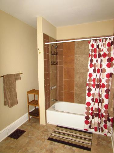 a bathroom with a tub and a shower curtain at Walk to the Falls from The Mint in Niagara Falls