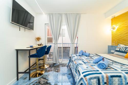 a bedroom with a bed and a desk and a window at Apartamentos Brisas del Poniente in Benidorm