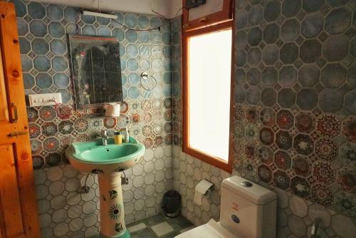 a bathroom with a sink and a toilet at Ailyak Stays and Cafe, Shoja, Jibhi in Shoja