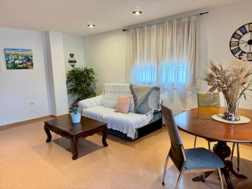 a living room with a couch and a table at Ático Luz del Valle in Dúrcal