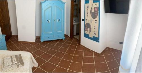 a room with a blue cabinet and a tiled floor at Domo Rosada in Ottava Sassari