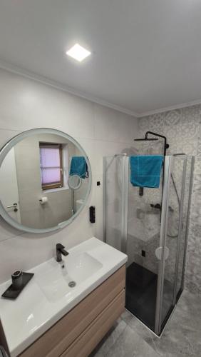 a bathroom with a sink and a shower with a mirror at Ferienwohnung Nahe Gmunden Top 3 in Pinsdorf