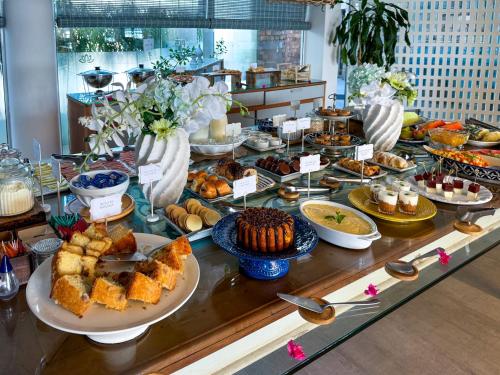 a buffet with many different types of desserts and pastries at Hotel Boutique Recanto da Passagem in Cabo Frio