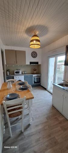 une cuisine avec une table et une salle à manger dans l'établissement Maison Calme au Centre du Village, à Puisserguier