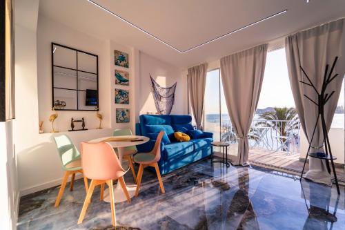 a living room with a blue couch and a table and chairs at Apartamentos Brisas del Poniente in Benidorm