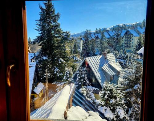 a view from a window of a house covered in snow at Willa Górska Szrenicówka in Szklarska Poręba