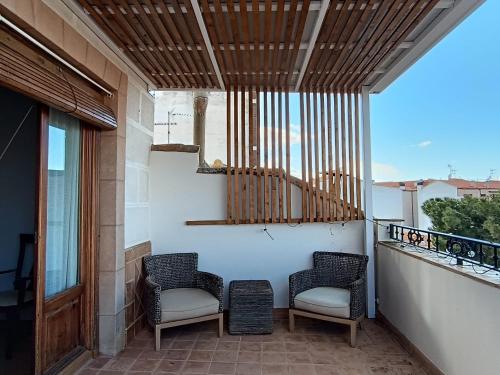 a porch with two chairs and a balcony at Apartamentos Turisticos La vida de antes in Consuegra
