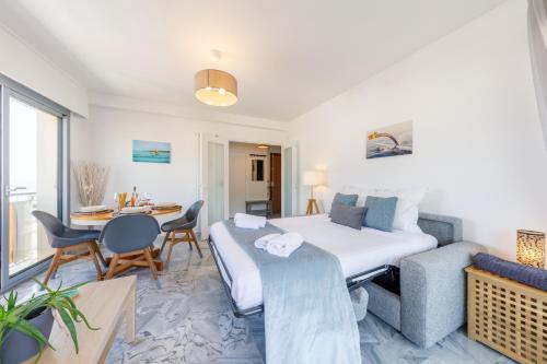 une chambre d'hôtel avec un lit et un coin repas dans l'établissement LA PERLE 2P Vue Mer Terrasse 2 mins Plage Garage Clim, à Roquebrune-Cap-Martin