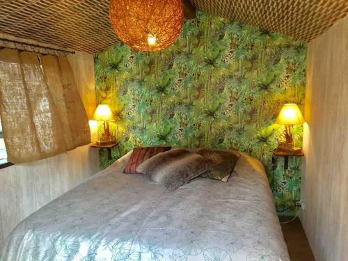 a bedroom with a bed with a green wall at Villa beldi in Lacanau