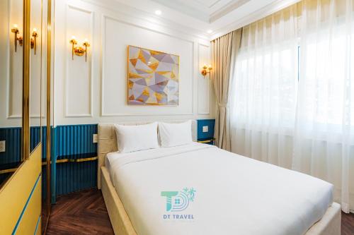 a bedroom with a white bed and a window at DT Retreat - Biệt thự nguyên căn - 3 Phòng ngủ - Novaworld Phan Thiết in Phan Thiet
