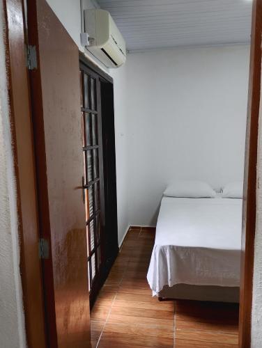 a bedroom with a bed and a door to a room at Espaço familiar em Cananeia SP in Cananéia