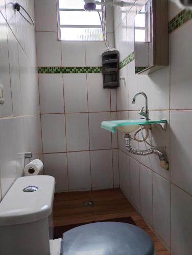 a small bathroom with a toilet and a sink at Espaço familiar em Cananeia SP in Cananéia