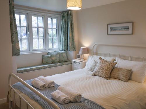 une chambre avec un lit avec deux serviettes dessus dans l'établissement Hope Cottage, à Beer