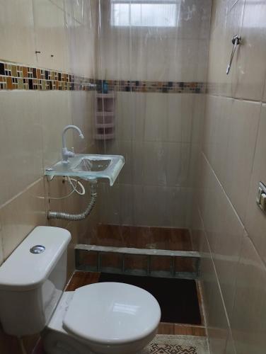 a bathroom with a toilet and a sink and a shower at Espaço familiar em Cananeia SP in Cananéia