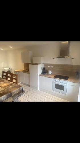 une cuisine avec une cuisinière et un comptoir dans l'établissement Maison à la campagne Grande cuisine tous équipés, grand salon , 3 chambres avec lits doubles, salle de bain et toilettes, à Fournols