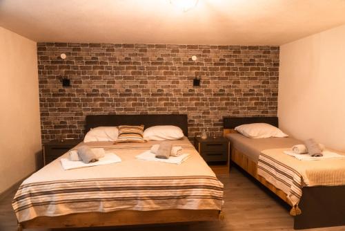 two beds in a room with a brick wall at Bakery apartments in Perea