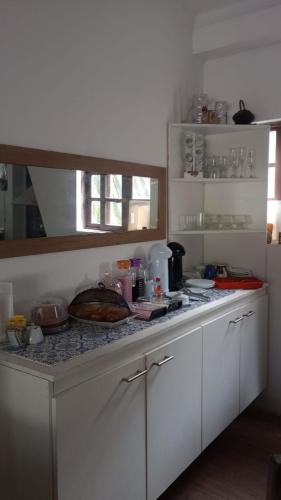 a kitchen with white cabinets and a counter top at Espaço familiar em Cananeia SP in Cananéia