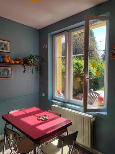 - une table rouge dans une chambre avec fenêtre dans l'établissement Cour et Jardin, à Revin