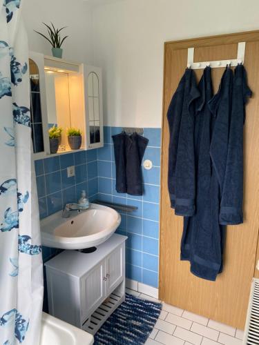 a blue bathroom with a sink and a mirror at Schöne Ferienwohnung mit Terrasse, nur 2 Minuten zur Autobahn in Wermelskirchen