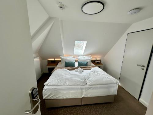 a bedroom with a white bed in a attic at Sandbank Hotel & Appartements Lubmin in Lubmin