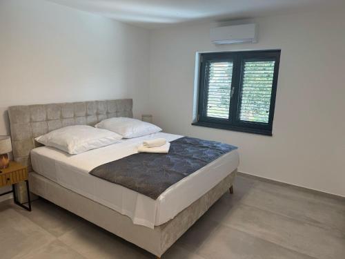 a bedroom with a large bed with a window at Villa Karla in Konjevrate