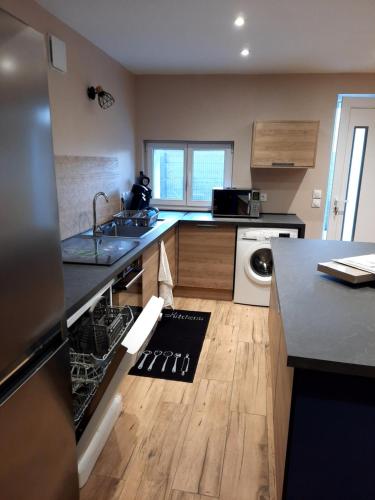 une cuisine avec un évier et un lave-vaisselle dans l'établissement L'atelier des rêves, à La Saulsotte