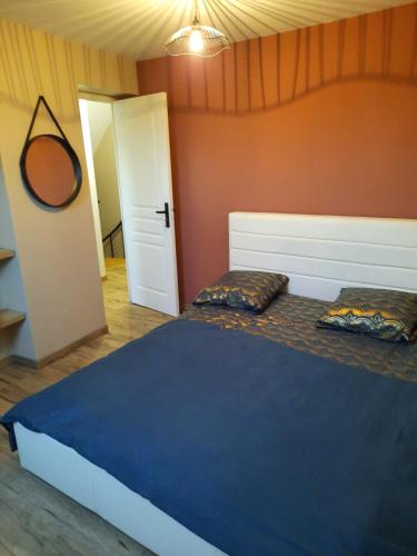 Un dormitorio con una cama con dos almohadas encima. en L'atelier des rêves, en La Saulsotte