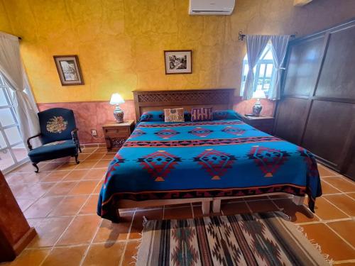 una camera da letto con un letto grande e una sedia di Casa Colonial, Cozumel Villa Indigo a Cozumel