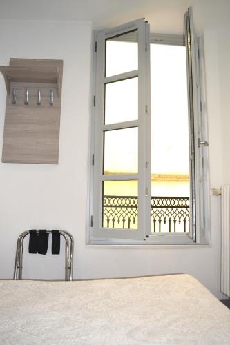 une chambre avec une fenêtre avec vue sur l'océan dans l'établissement Hôtel Concorde - Centre ville de Nimes, à Nîmes