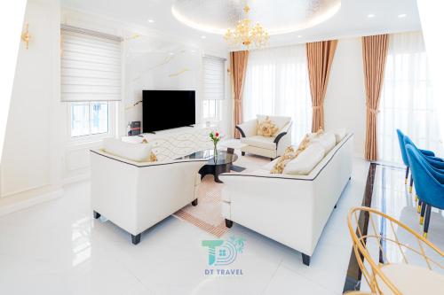 a living room with white furniture and a tv at DT Retreat - Biệt thự nguyên căn - 3 Phòng ngủ - Novaworld Phan Thiết in Phan Thiet