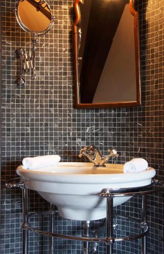 a bathroom with a sink and a mirror at Suitehotel Posthoorn in Monnickendam