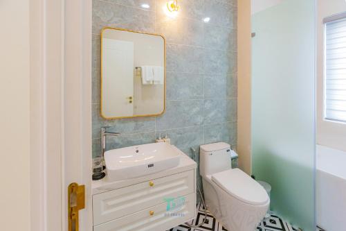 a bathroom with a sink and a toilet and a mirror at DT Retreat - Biệt thự nguyên căn - 3 Phòng ngủ - Novaworld Phan Thiết in Phan Thiet