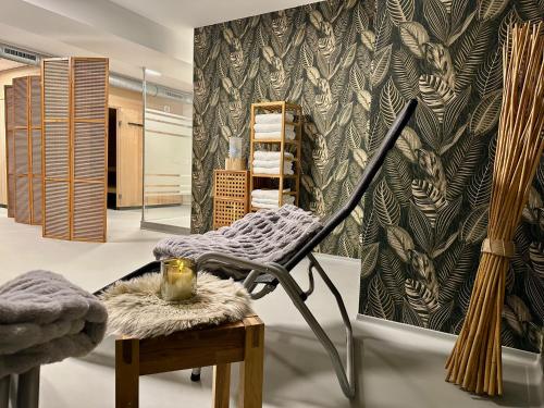a dressing room with a chair and a bench and a wall at Sandbank Hotel & Appartements Lubmin in Lubmin