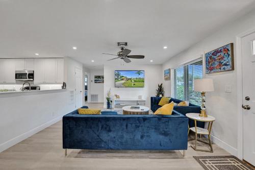 a living room with a blue couch and a kitchen at Private Room in Spacious 3-Bedroom Home in Fort Lauderdale